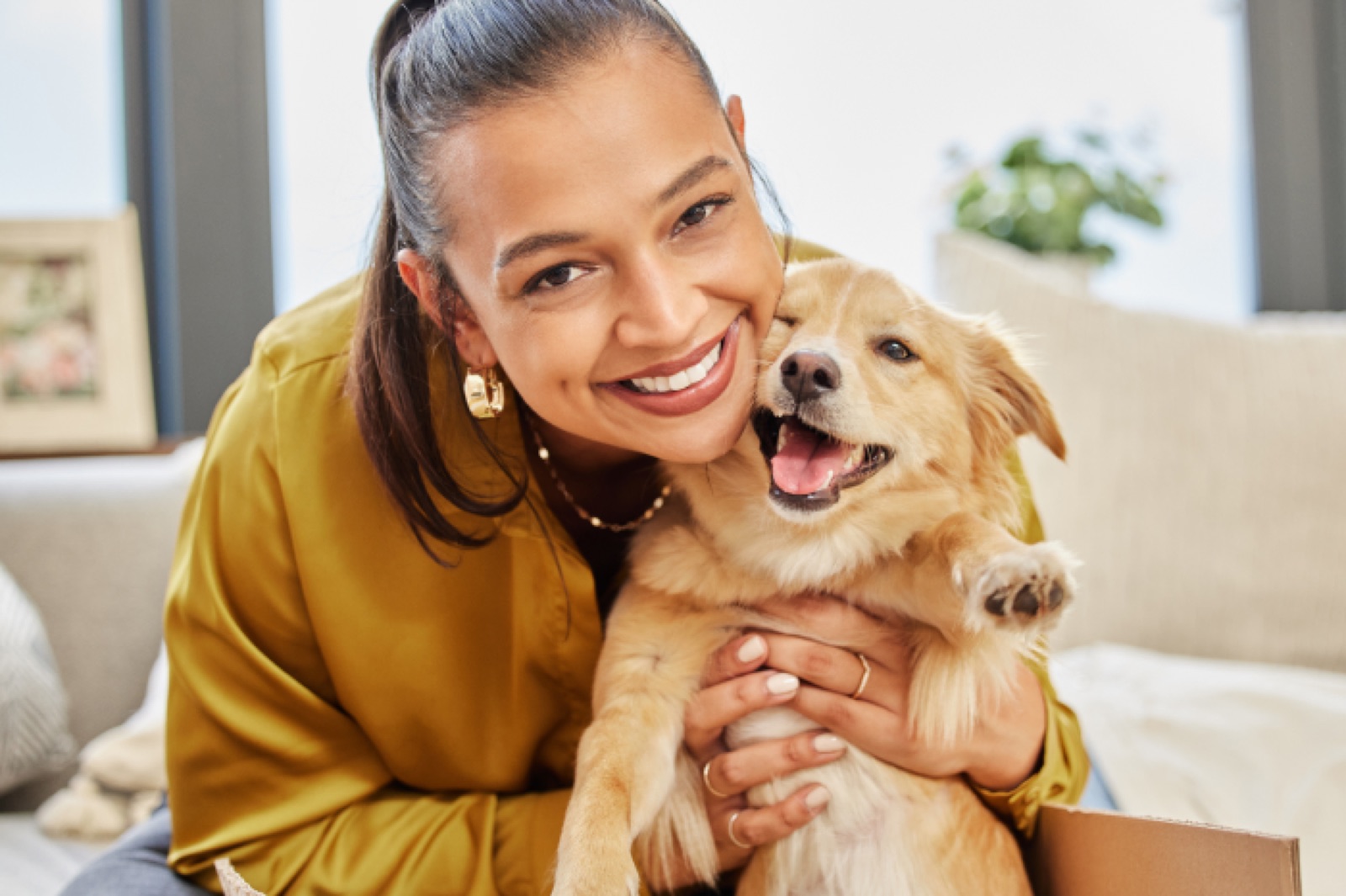 A woman hugging her golden retriever puppy